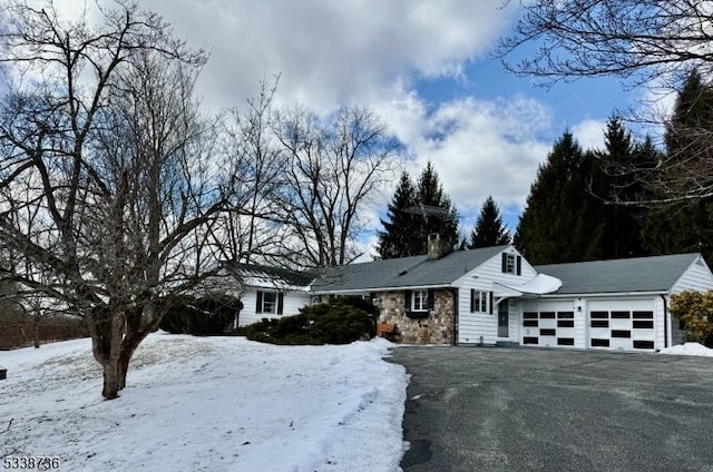 view of front of property with stone siding, a chimney, and an attached garage