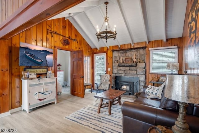 living area with beam ceiling, a healthy amount of sunlight, and wood walls