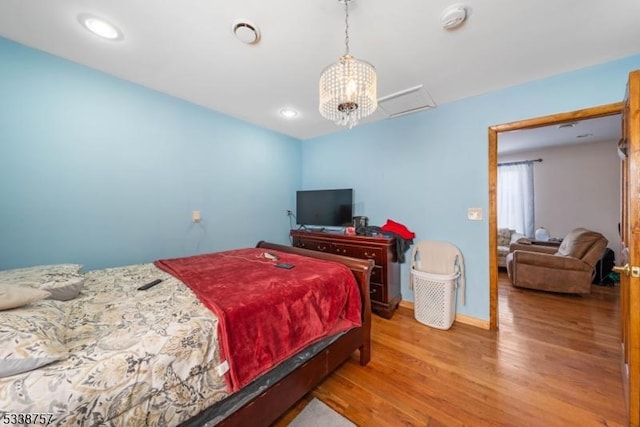 bedroom with an inviting chandelier and light hardwood / wood-style floors