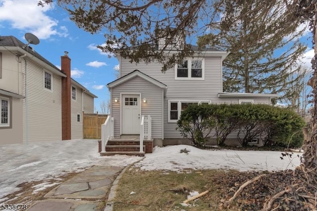 view of front of home featuring entry steps and fence