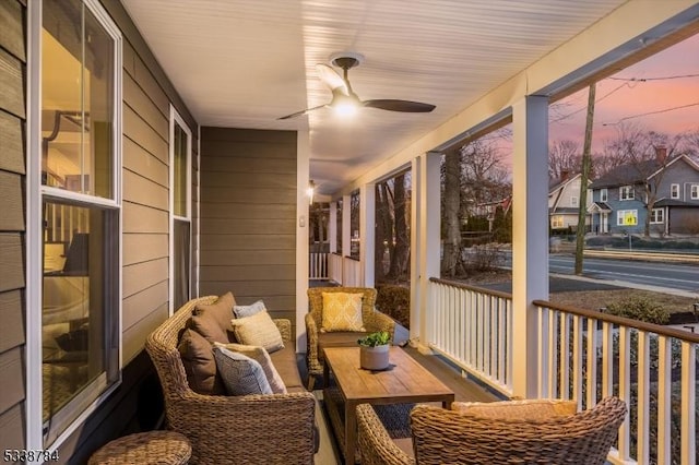 sunroom featuring ceiling fan and a residential view