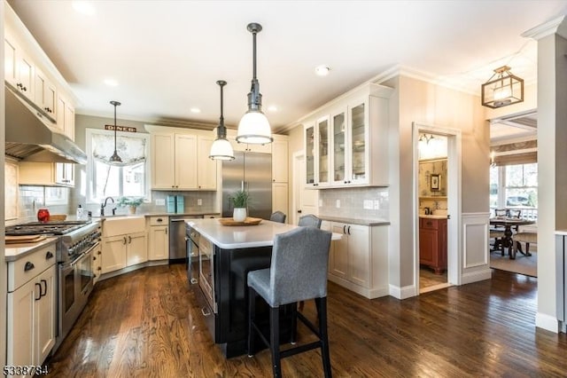 kitchen featuring ornamental molding, a center island, light countertops, and high quality appliances