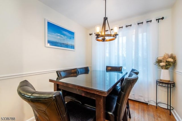 dining room with hardwood / wood-style flooring and a chandelier