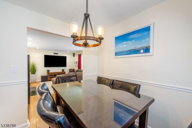 dining space with hardwood / wood-style flooring and a chandelier