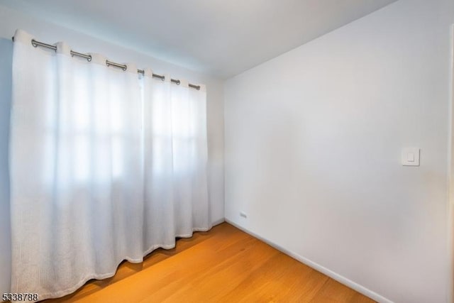 unfurnished room with hardwood / wood-style flooring