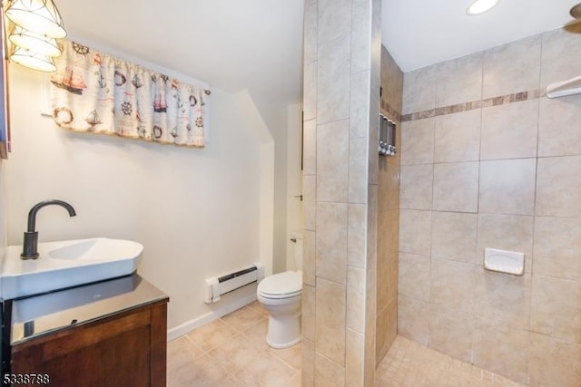 bathroom featuring tile patterned flooring, toilet, a tile shower, a baseboard radiator, and vanity