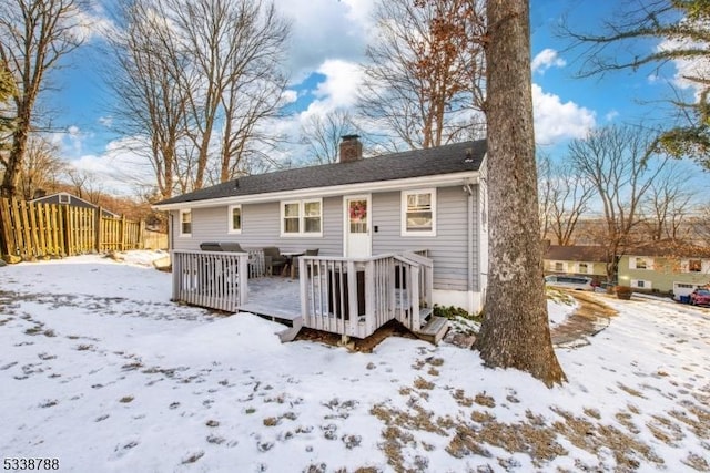 snow covered house featuring a deck