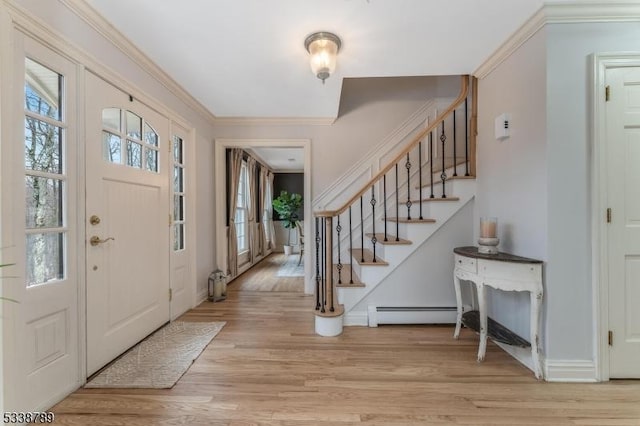 entryway featuring baseboards, stairs, baseboard heating, crown molding, and light wood-type flooring