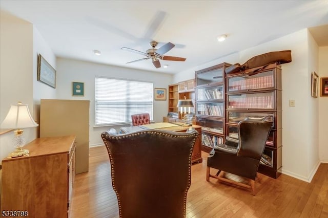 sitting room featuring light wood-style floors, baseboards, and a ceiling fan