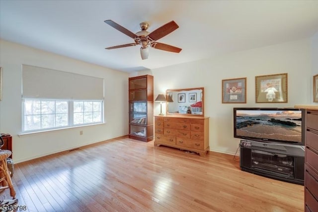 interior space with light wood finished floors, visible vents, and a ceiling fan