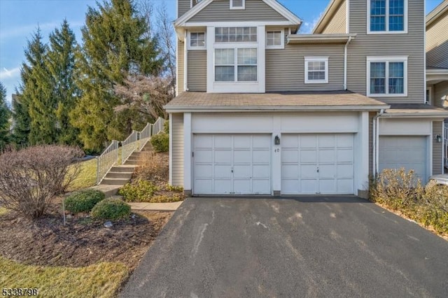 view of front of home with a garage, driveway, and fence