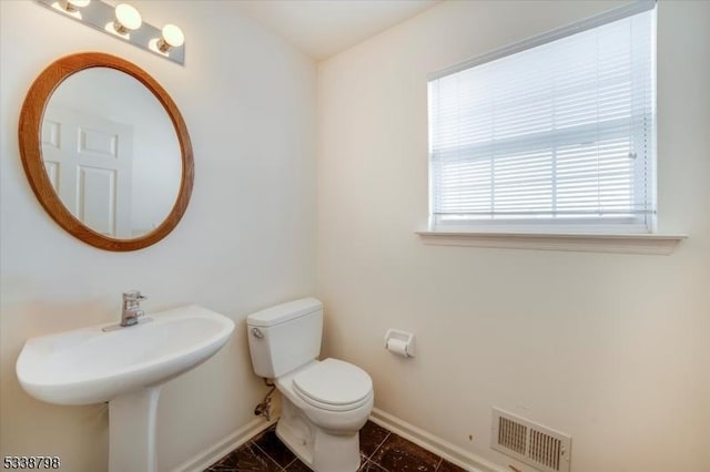 bathroom with toilet, tile patterned floors, visible vents, and baseboards