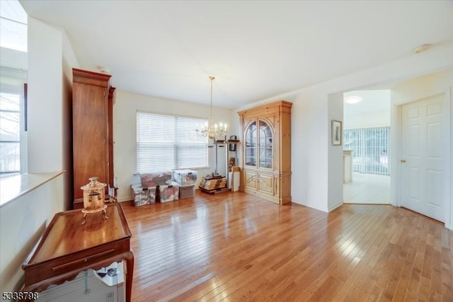 dining room with light wood finished floors and a notable chandelier