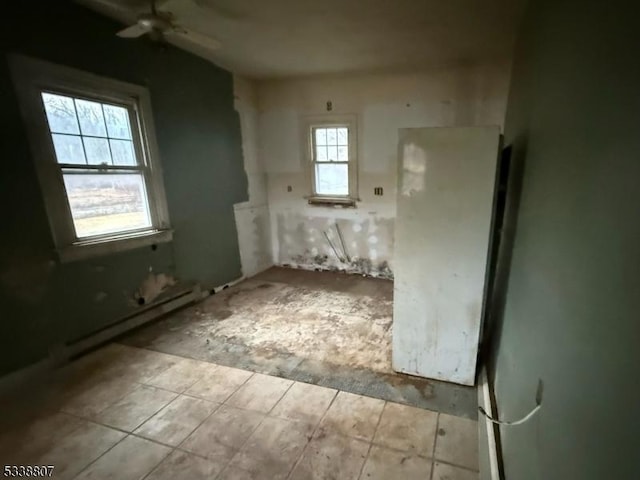 empty room featuring baseboard heating and ceiling fan