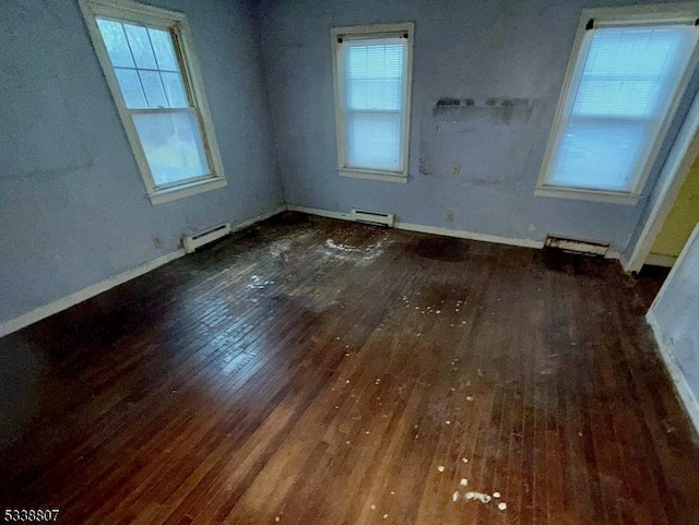 spare room featuring dark hardwood / wood-style flooring and baseboard heating