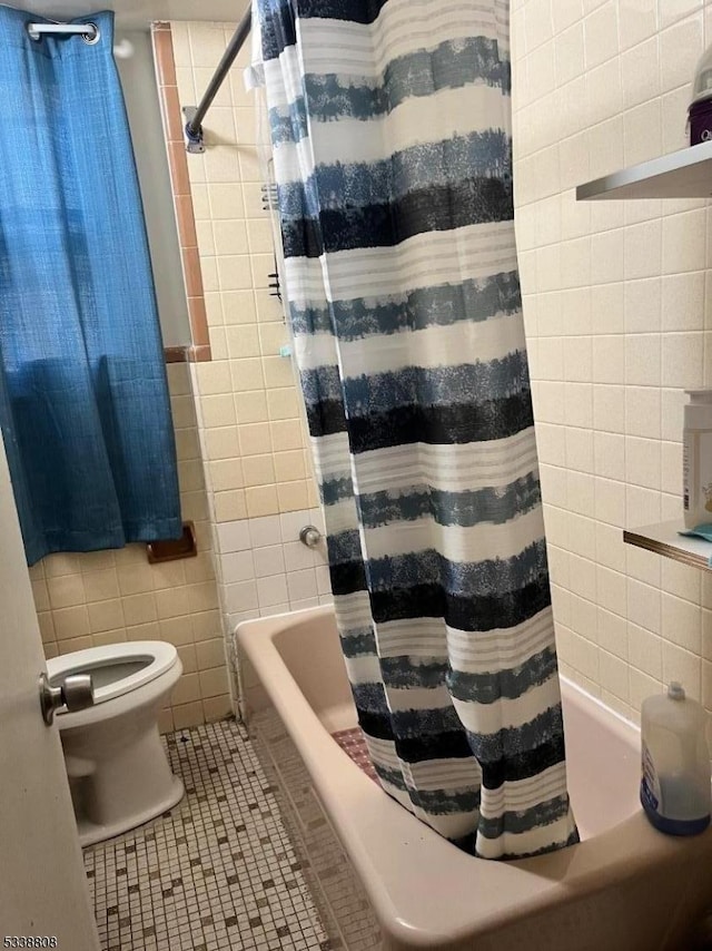 bathroom featuring shower / tub combo with curtain, toilet, tile walls, and tile patterned flooring