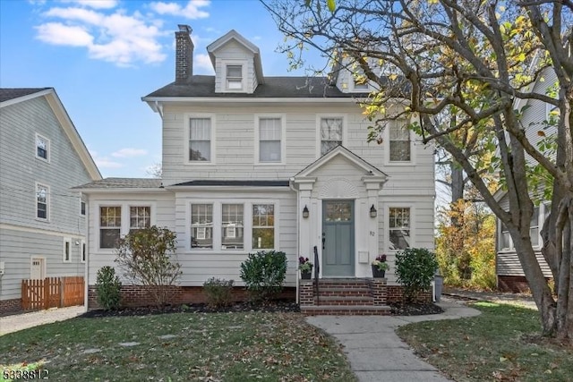 view of front of home featuring a front yard, fence, and a chimney