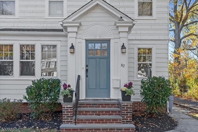 doorway to property with roof with shingles