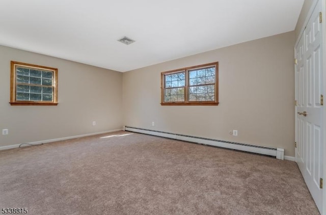 unfurnished room with visible vents, a baseboard heating unit, baseboards, and light colored carpet