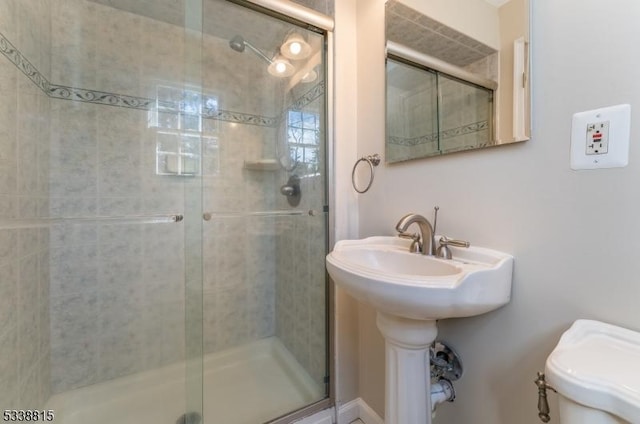 bathroom featuring a stall shower and toilet