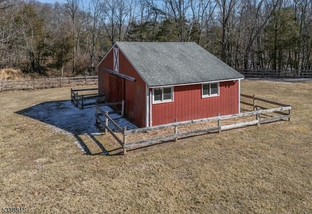 view of outdoor structure featuring fence and an outbuilding