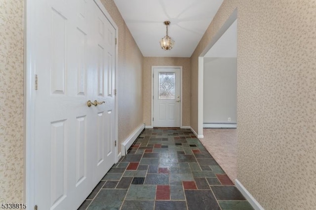 entryway featuring a baseboard heating unit, stone finish flooring, baseboards, and wallpapered walls