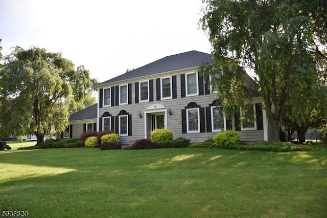 colonial-style house featuring a front yard