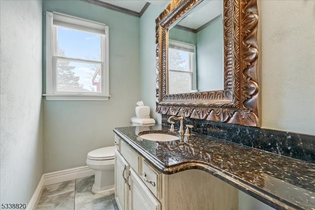 bathroom with baseboards, crown molding, vanity, and toilet