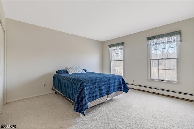 carpeted bedroom featuring a baseboard radiator, multiple windows, and baseboards