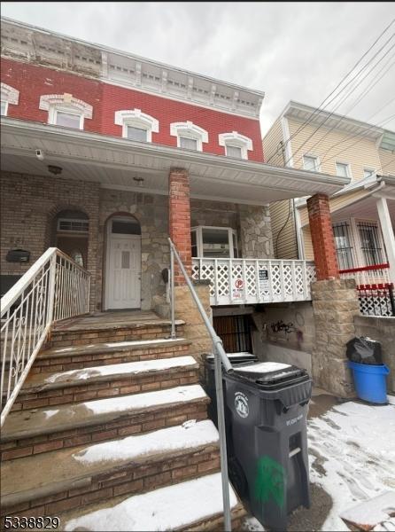 entrance to property featuring a porch and brick siding