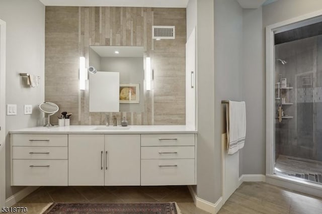 full bathroom with visible vents, a stall shower, vanity, tile patterned flooring, and baseboards