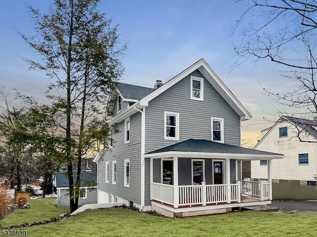 view of front of home with a porch and a lawn