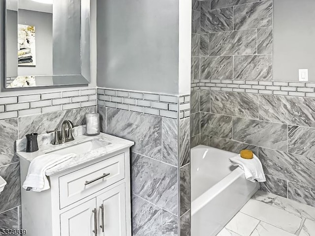 bathroom with tile walls, a bathtub, and vanity