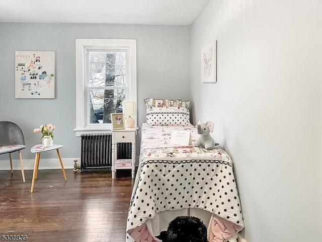 bedroom featuring radiator and dark hardwood / wood-style floors