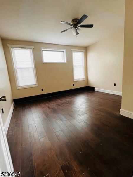 spare room with ceiling fan, baseboards, and wood finished floors