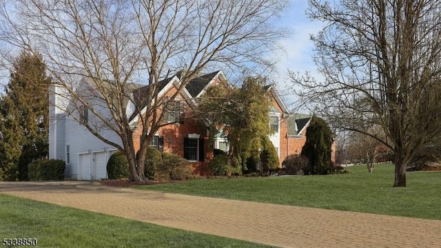 view of front of property featuring driveway, a front lawn, and brick siding