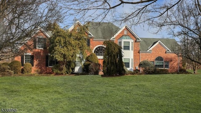 view of front of house with brick siding and a front lawn