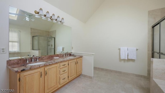 bathroom with double vanity, lofted ceiling with skylight, a sink, and a shower with shower door