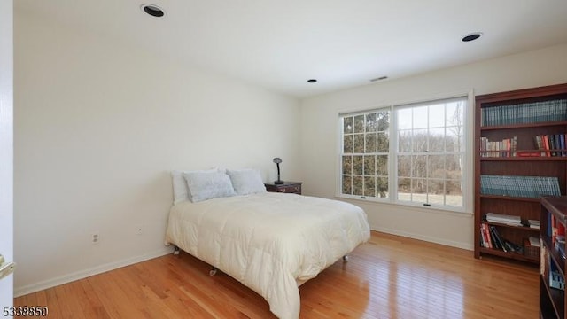 bedroom featuring baseboards, wood finished floors, and recessed lighting