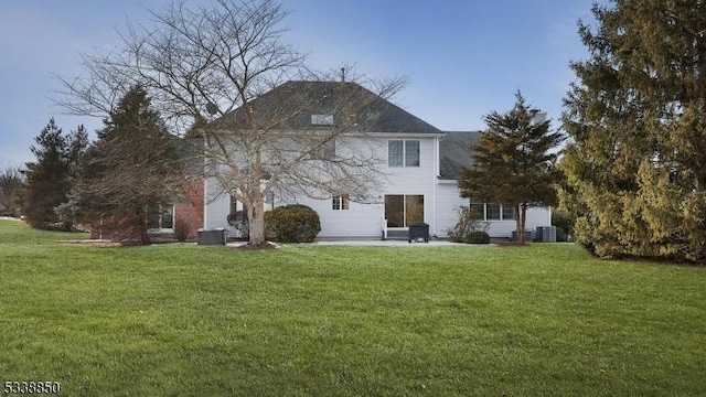 back of property with a patio area, central AC, and a lawn