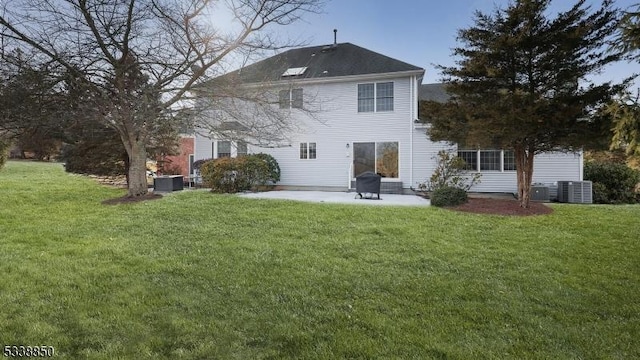 back of house with cooling unit, a yard, and a patio