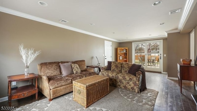 living area with baseboards, crown molding, visible vents, and wood finished floors