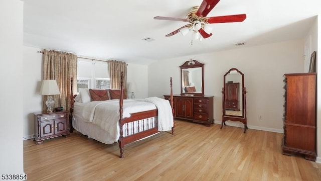 bedroom featuring baseboards, ceiling fan, visible vents, and light wood-style floors