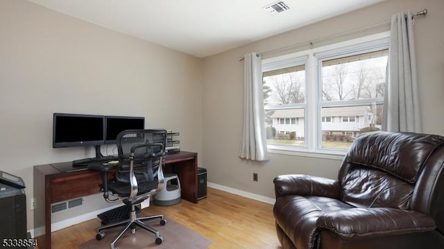 office with baseboards, visible vents, and wood finished floors