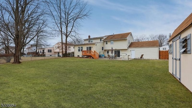 back of house featuring a residential view, a lawn, and fence