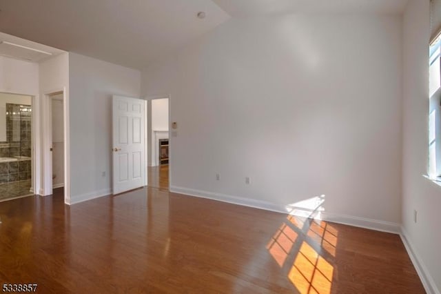 interior space featuring a fireplace, baseboards, wood finished floors, and multiple windows