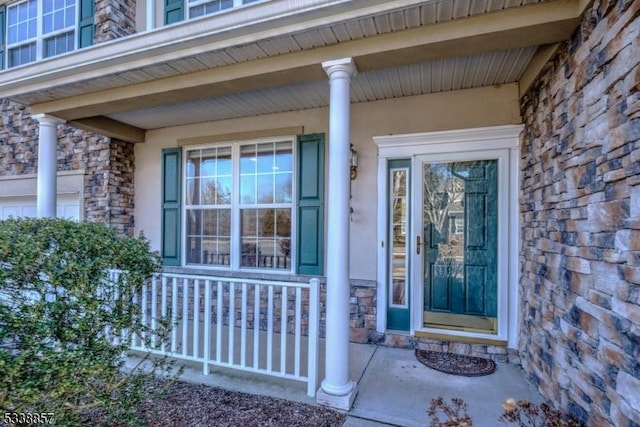 property entrance with stone siding and a porch