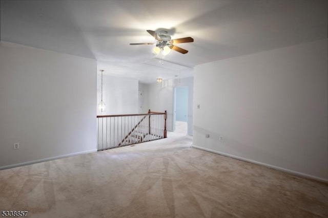 spare room featuring attic access, carpet floors, and baseboards