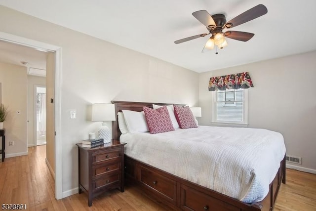 bedroom featuring ceiling fan, light wood-type flooring, visible vents, and baseboards