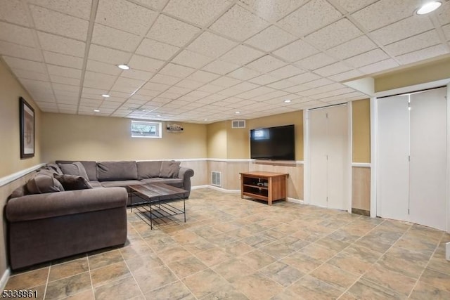 living room featuring a paneled ceiling, a wainscoted wall, visible vents, and recessed lighting